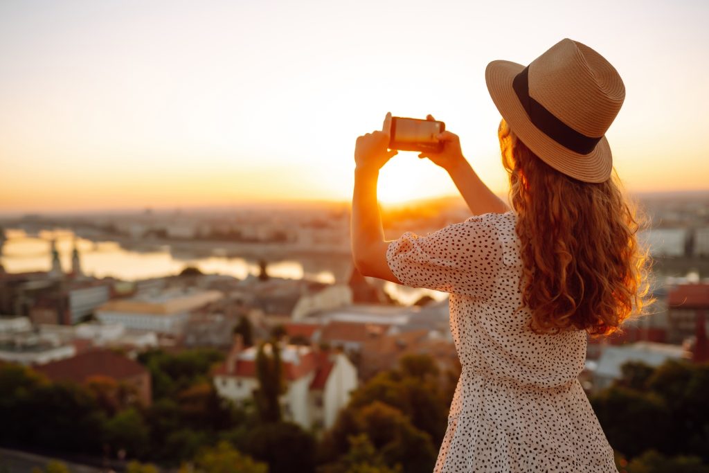 Travel in Europe. Young woman enjoys sunrise. The concept of travel, tourism, vacation and freedom.